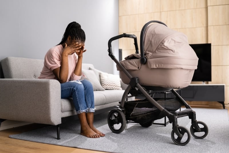 Distressed Woman on Couch with Baby Stroller