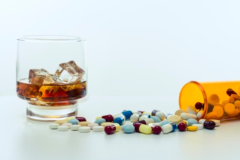 Glass of Alcohol and Bottle of Pills